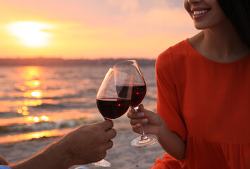 Canvas Print - Lovely couple having picnic near river at sunset, closeup