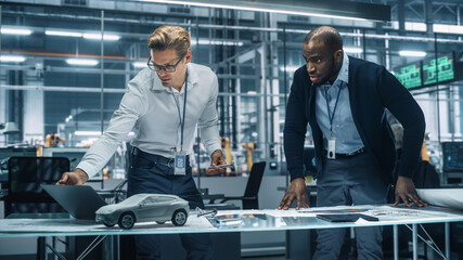 Poster - Two Automotive Engineers Working in Office at Car Factory. Industrial Designer Shows Conceptual Electric Engine Parts to Colleague, Discussing Different Applications in Technological Laboratory.
