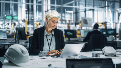 Poster - Young Beautiful Engineer Working and Managing Projects on Laptop Computer in an Office at Car Assembly Plant. Industrial Specialist Working on Vehicle Parts in Technological Development Facility.