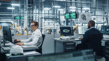 Leinwandbilder - Team of Automotive Engineers Working on Desktop Computers in Modern Office at Car Assembly Plant. Industrial Product Designer Developing Electric Engine Parts with Colleagues at Vehicle Factory.