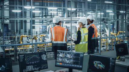 Leinwandbilder - Young Diverse Team of Automotive Engineers Working in Office at Car Factory. Industrial Designer Talks About Electric Engine Parts with Colleagues, Discussing Different Technological Applications.