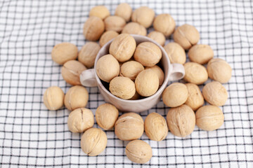 Aufkleber - A lot of whole walnuts in a cup on a napkin closeup. Healthy, organic and healthy food with a high content of protein and protein.