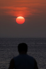 Silhouette Of Anonymous Traveler Enjoying Sunset On Seashore