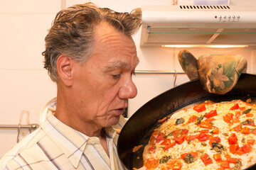 Wall Mural - Mature Man in his Kitchen Admiring his Homemade Pizza