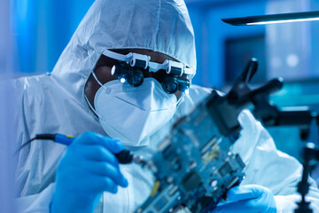 African-American scientist works in a modern scientific laboratory for the research and development of microelectronics and processors. Manufacturing worker uses computer technology and equipment.