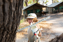 Young Boy In Tented Safari Camp Holding A Model Airplane. 
