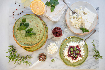 Wall Mural - Close-up of pink pancakes with beetroot and feta, and green pancakes with spinach