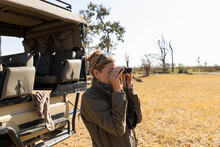 Woman Using Binoculars On A Game Drive In A Nature Reserve