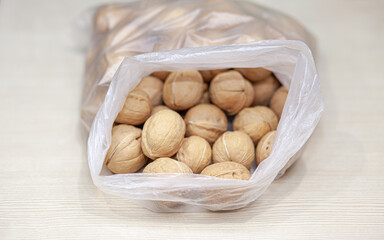Aufkleber - A lot of whole walnuts in a bag on a white background. Healthy, organic food with a high content of protein and protein.