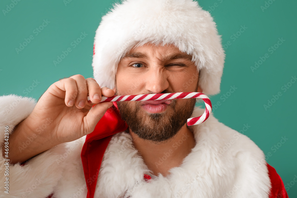 Santa Claus with candy cane on green background, closeup