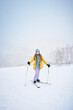 © Mikhail Mishchenko - Portrait of cheerful skier girl in yellow jacket in a snowy weather