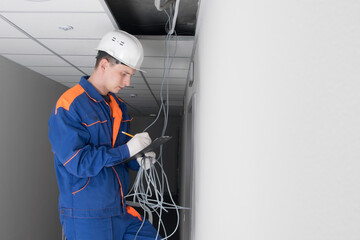 Wall Mural - a master in a blue uniform, keeps track of the hidden-mounting electric mains of the false ceiling, there is a place for an inscription