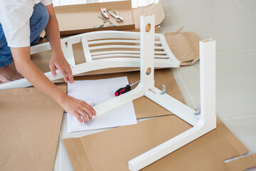 Wall Mural - Man assembling white chair furniture at home