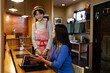 © Monet - 客とコミュニケーションをとる、飲食店の女性店員