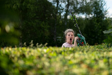 Woman Pruning Hedge