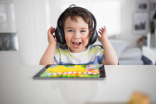 Boy In Headphones Using Digital Tablet