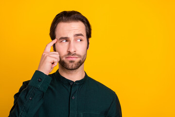 Poster - Photo of doubtful unsure young man wear smart casual outfit finger head temple looking empty space isolated yellow color background