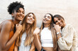 © Lomb - Joyful Girlfriends Having Fun Standing Against a Wall - A Group of Cheerful young Women Gather Carefree