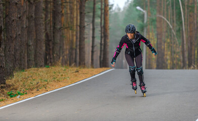 Roller skating sports girl in a helmet outdoors.