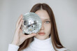 © Irina_Evva - Fashion portrait of a teenage girl with a disco ball, covering her face