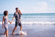 © Loginova - Vacation near the sea. Family with little kid walking on the beach.