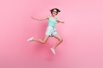 Poster - Full length body size view of attractive funny cheerful girl jumping having fun isolated over pink pastel color background