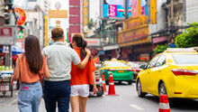 Group Of Asian People Friends Tourist Walking And Shopping Together At Chinatown In Bangkok City, Thailand. Male And Female Friend Enjoy And Having Fun Outdoor Lifestyle Travel And Eating Street Food.