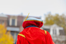 A Little Girl With Hood And Red Shawl (cosplay Cloth) On Shoulder Of Their Parent, A Sinterklaas Entry Or Arrival (Intocht Van Sinterklaas) Is A Tradition In The Netherlands, Canal Of Amsterdam.