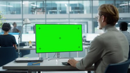 Poster - Close Up Over the Shoulder Shot of a Businessman Working on Desktop Computer with Chroma Key Green Screen Mock Up Display. Digital Projects Manager Typing Data, Using Keyboard and Mouse.