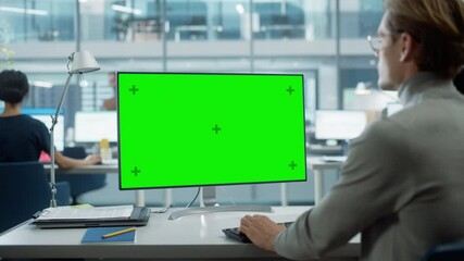 Leinwandbilder - Close Up Over the Shoulder Shot of a Businessman Working on Desktop Computer with Chroma Key Green Screen Mock Up Display. Digital Projects Manager Typing Data, Using Keyboard and Mouse.