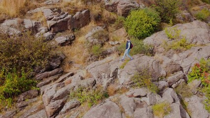 Wall Mural - young woman hiking on the rocky trail in the autumn mountains.