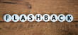 Flashback symbol. The concept word Flashback on white circles. Beautiful wooden table, wooden background. Business and flashback concept. Copy space.