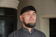Close up portrait of serious senior asian muslim man wearing skullcap.