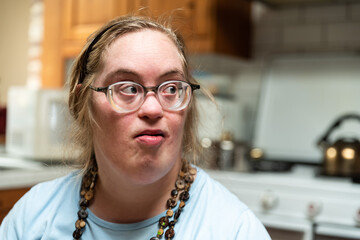 Indoor portrait of a 39 year old woman with Down Syndrome in the kitchen at home