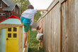 © Cavan Images - Two children climb and play together in backyard