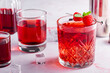 red cocktail with raspberries on a pink background