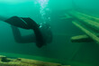 SCUBA diver entering the cabin trunk of wooden schooner shipwreck