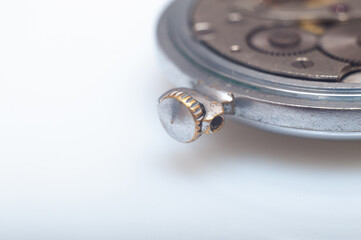 Close up view of the gears and mainspring in the mechanism of a silver pocket watch on old paper