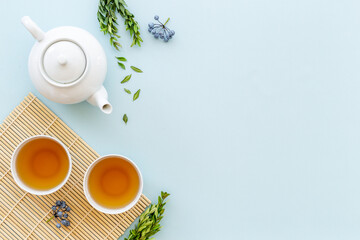 Tea drinking with white teapot and black tea in two cups