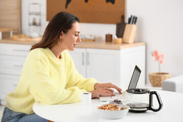 Canvas Print - Morning of beautiful woman with laptop drinking coffee at home