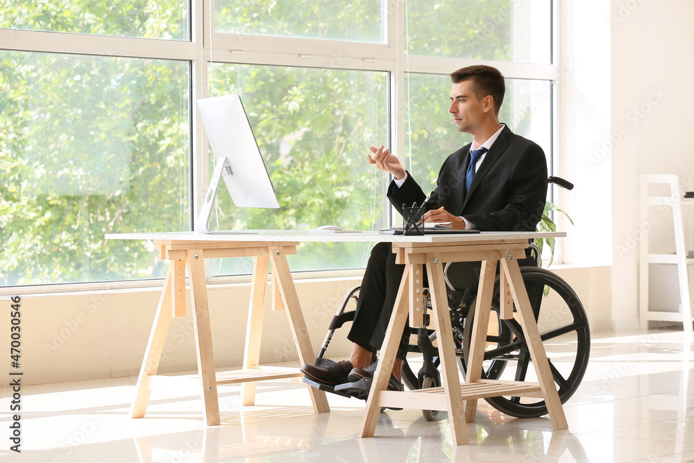 Young businessman with physical disability working in office
