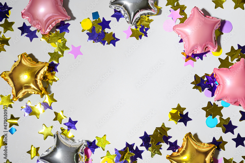 Frame made of beautiful balloons and confetti on light background