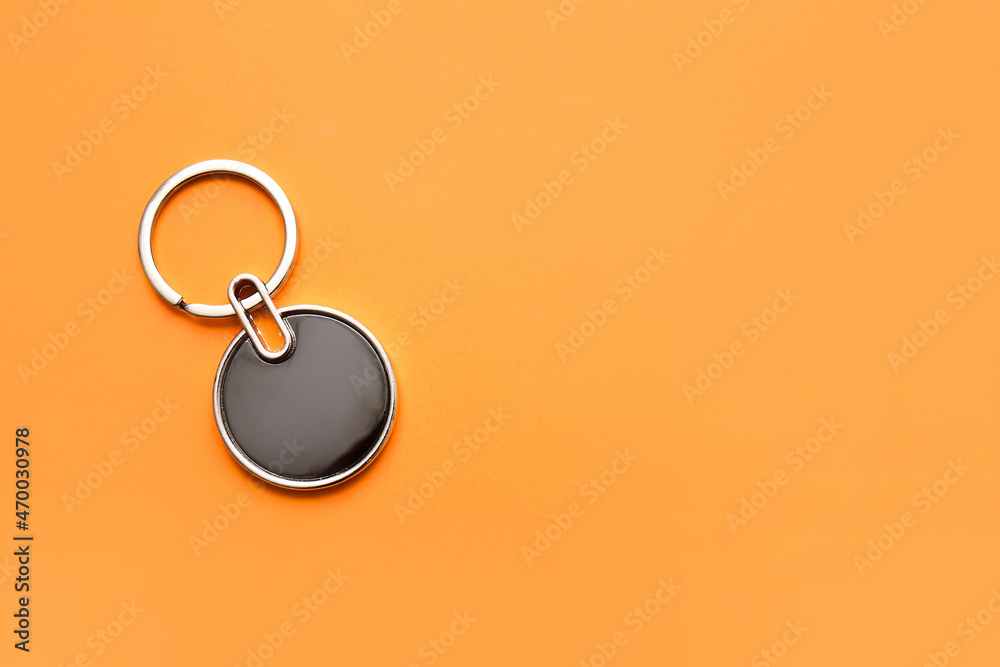 Stylish round keychain on orange background