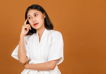 Wall Mural - Portrait studio shot of millennial young Asian short black hair female model in white shower rope standing and posing pose in advertising action on brown background