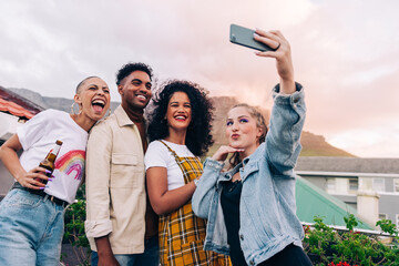 Wall Mural - Happy friends taking a group selfie outdoors