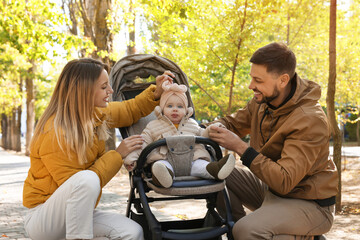 Sticker - Happy parents with their baby in stroller at park on sunny day