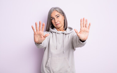 Wall Mural - senior pretty woman looking serious, unhappy, angry and displeased forbidding entry or saying stop with both open palms