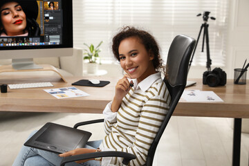 Fototapete - Professional African American retoucher working with graphic tablet at desk in office