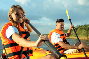 Sticker - Couple in life jackets kayaking on river. Summer activity