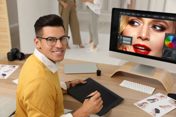 Fototapete - Professional retoucher working with graphic tablet at desk in photo studio